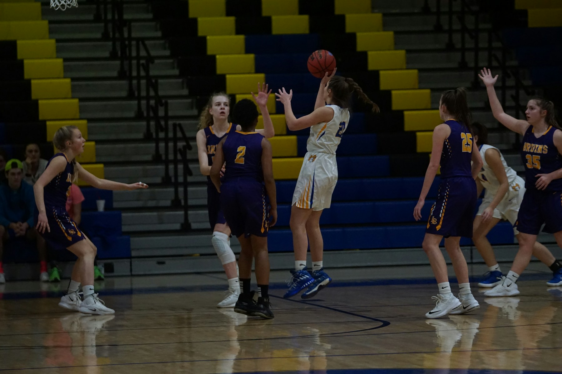 Girls competing in an indoor basketball game